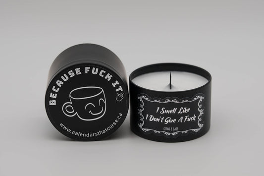 A black candle with a wood wick that has the words, I smell like I dont give a fuck written on the front. 